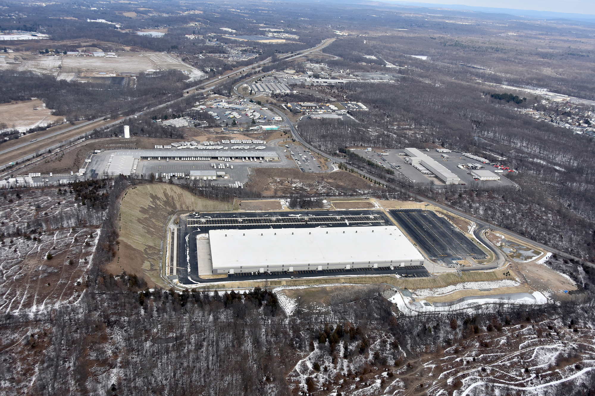 An aerial view of a large distribution warehouse in snowy conditions