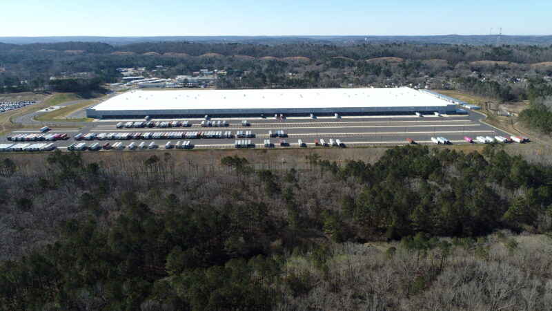 A large distribution warehouse with many trailers parked