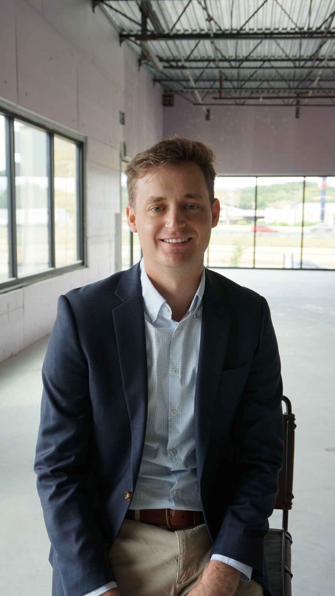Picture of a young man in a suit inside an office building